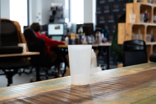 gobelet personnalisé à l’unité posé sur une table dans un lieu de travail